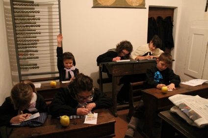 SCUOLA/SCHOOL: Local kids act as pupils in a very small “shcořa”, Kye for school, in which an old abacus and planisphere can be observed. (Performers: Maria Capra, Sofia Maule, Francesca Luciano, Beatrice Luciano, Gloria Anfossi, Lorenzo Sevega) (Gianluca Avagnina Photography)